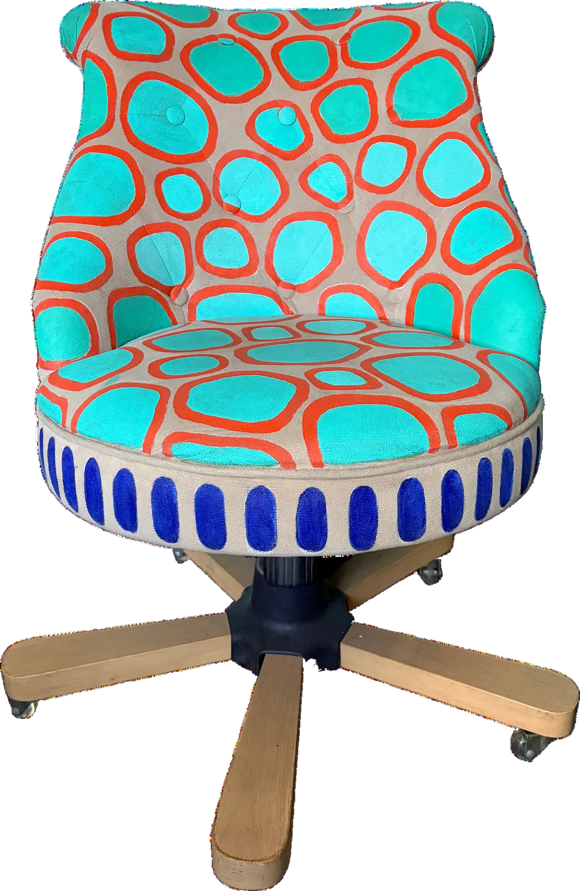 Silla giratoria tapizada a mano en naranjo con óvalos turquesa, base de madera clara y una franja de arcos azules en el borde del asiento.